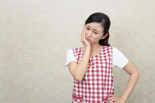 落ち込むエプロン姿の女性 落ち込むエプロン姿の女性 女性,考える,疑問の写真素材