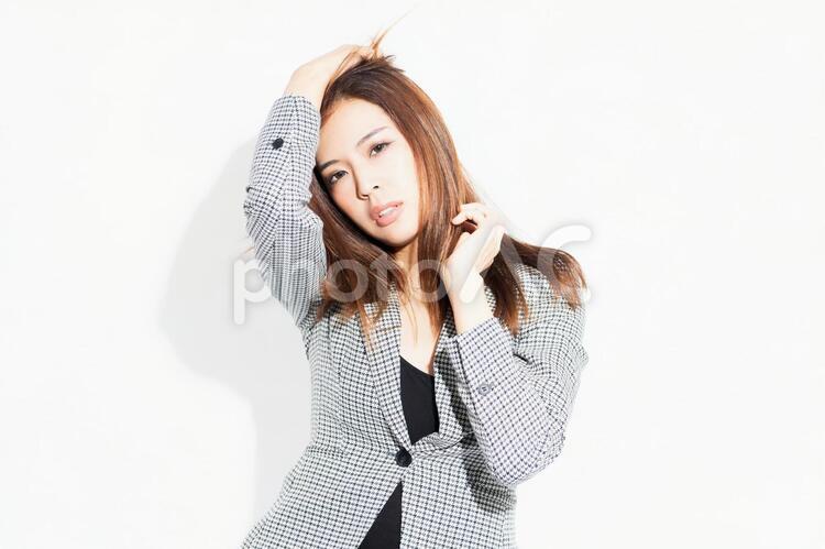 白い背景の前に立ってポーズをとる若いビジネスウーマン 女性,白背景,立つの写真素材