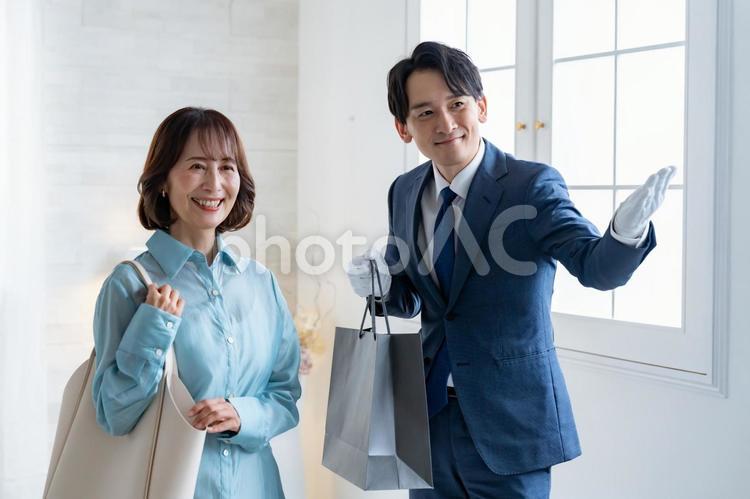 買い物の袋を持つスーツの男性と女性客 ショッピング,コンシェルジュ,ブランドの写真素材