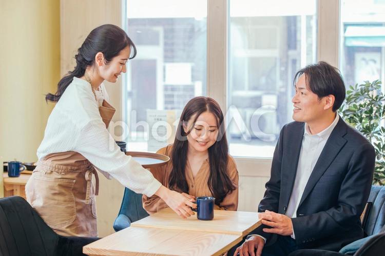 カフェにきた男女とホールスタッフ カフェ,コーヒー,コーヒーショップの写真素材