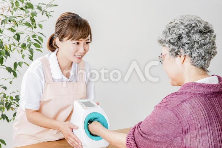 血圧を測る介護士と高齢者の女性 高齢者,血圧,血圧計の写真素材