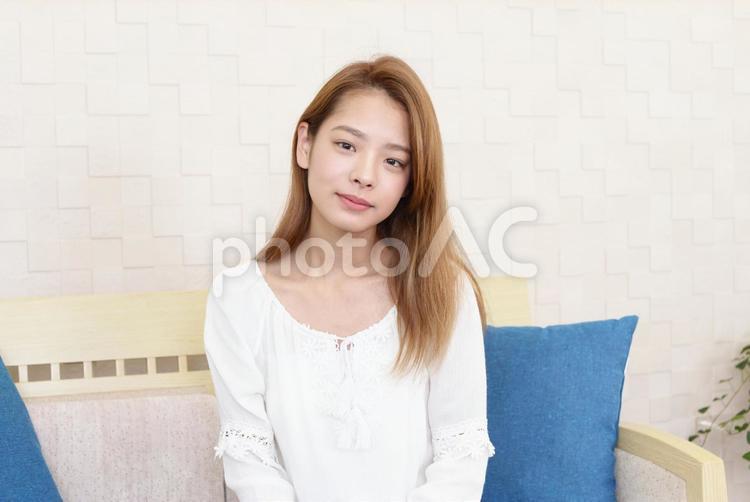 ソファに座り微笑む女性 女性,笑顔,微笑むの写真素材