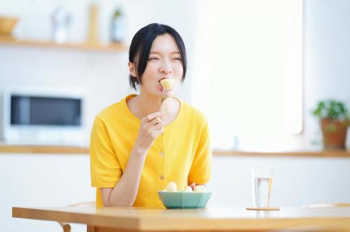 フルーツを頬張り微笑む女性 女性,リンゴ,食べるの写真素材