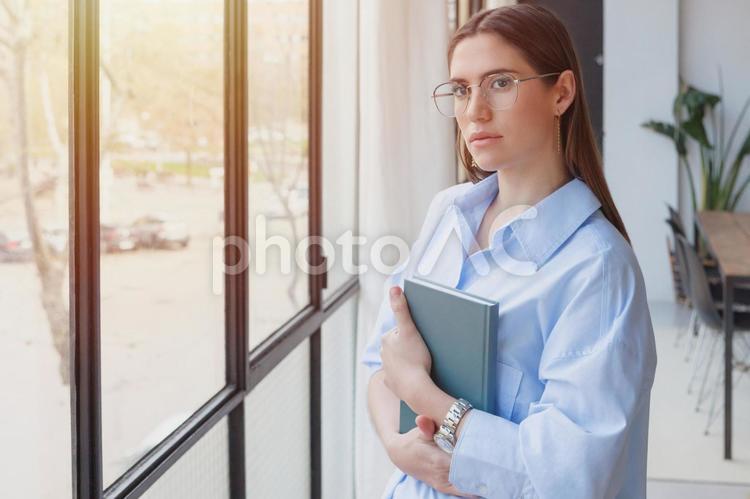 本を抱える眼鏡の女性 女性,本,持つの写真素材