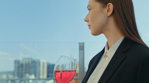 赤いドリンクのグラスを持つ女性の横顔 女性,外国人,ワイングラスの写真素材