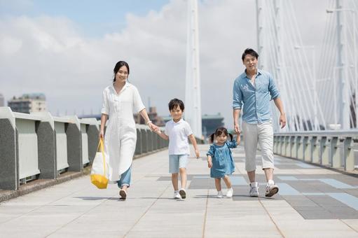 手を繋いで屋外を散歩する親子 手を繋いで屋外を散歩する親子 人物,家族,女性の写真素材