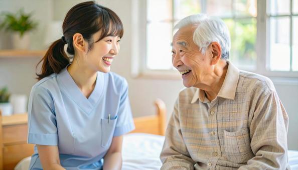 笑顔で話をする女性介護士と高齢男性 笑顔で話をする女性介護士と高齢男性の写真
