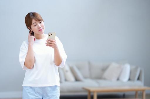 スマホを見ながら考える女性 女性,スマートフォン,持つの写真素材