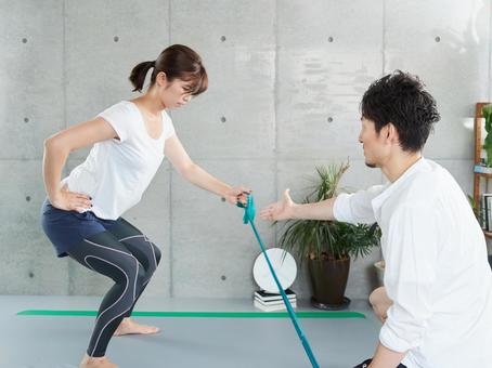 Japanese woman receiving tube training instruction from a personal trainer Japanese woman receiving tube training instruction from a personal trainer