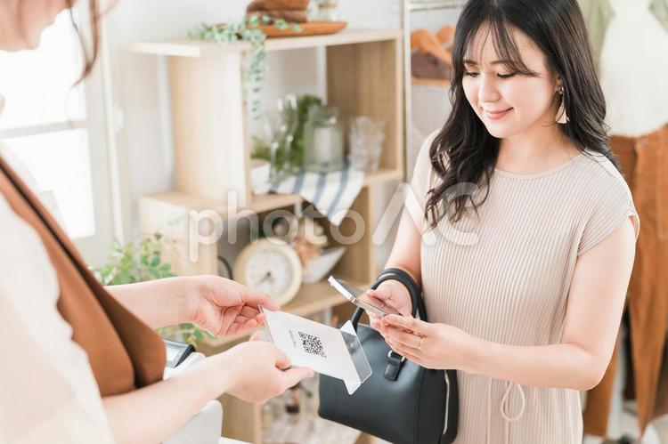 二次元バーコード決済・スマホ決済をする女性 二次元コード決済,電子マネー,買い物の写真素材