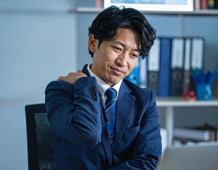 辛い肩凝りで苦しむ男性 辛い肩凝りで苦しむ男性の写真