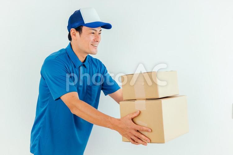 段ボールを持った作業着の男性 引越し,配達員,ダンボールの写真素材