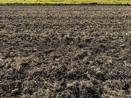 稲刈り後にトラクターでかき混ぜた田んぼの写真