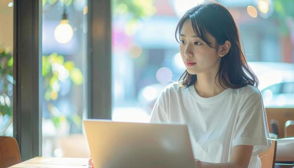 カフェでノートパソコンを使う日本人女性の写真