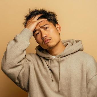 眉間にシワを寄せ、困り果てた様子の男性 眉間にシワを寄せ、困り果てた様子の男性の写真