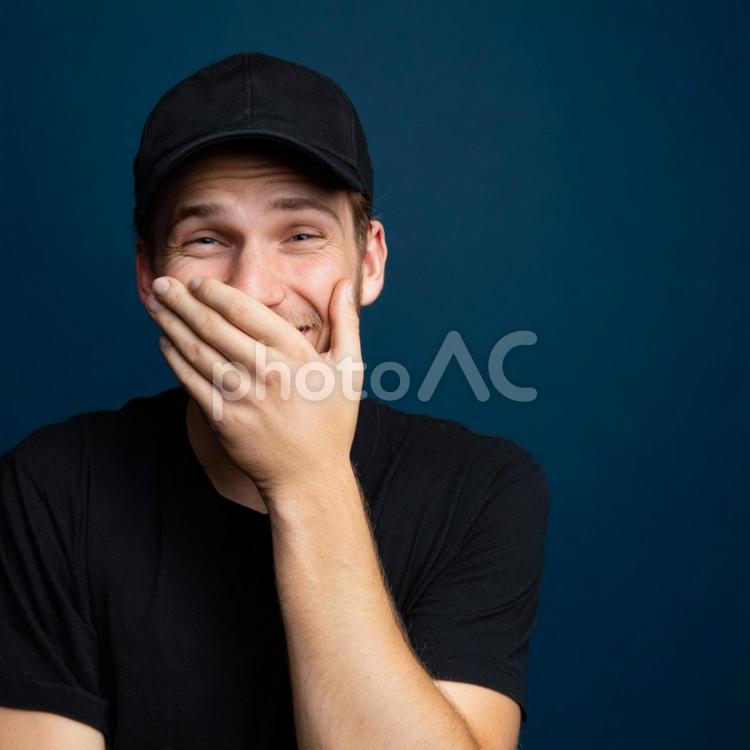 黒いキャップをかぶって笑顔を見せる男性 男性,笑う,笑顔の写真素材