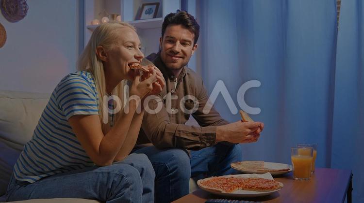 ピザを食べる女性と見ている男性 男女,男性,女性の写真素材