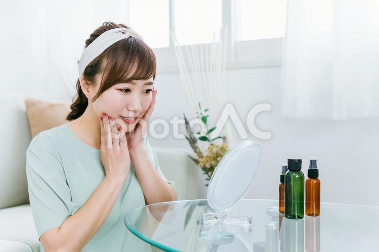 鏡を見ながらコスメで保湿する日本人女性 スキンケア,保湿,化粧の写真素材