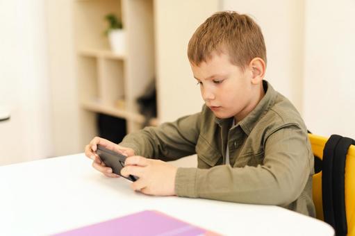 携帯を真剣に見て学習する男の子 男の子,子ども,人物の写真素材