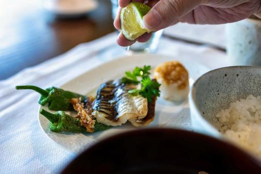 焼き魚にすだちを掛ける。 焼き魚,和食,レストランの写真素材