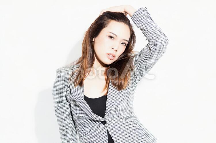 白い背景の前に立ってポーズをとる若いビジネスウーマン 女性,白背景,立つの写真素材