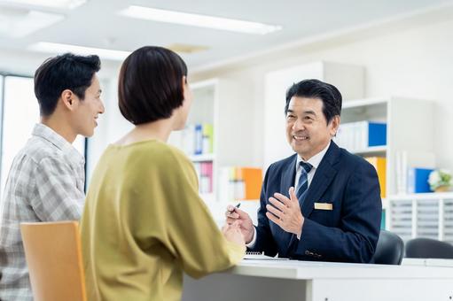 夫婦に説明するプランナー 夫婦に説明するプランナーの写真