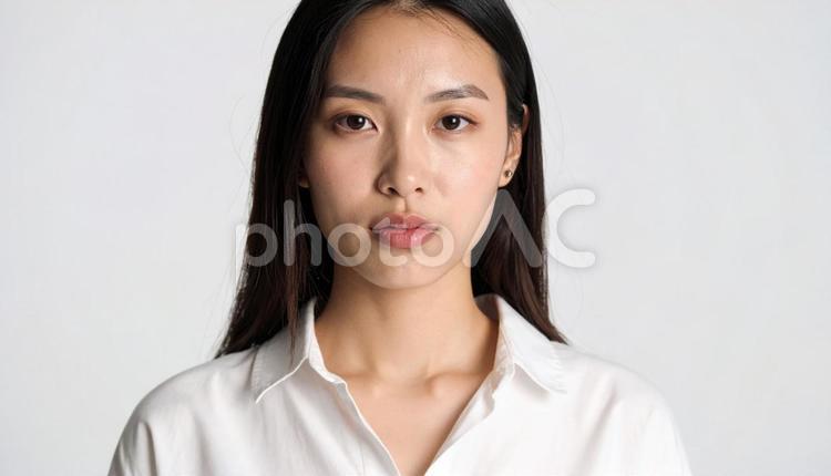 白シャツの真剣な表情の女性のポートレート 人物,女性,20代の写真素材