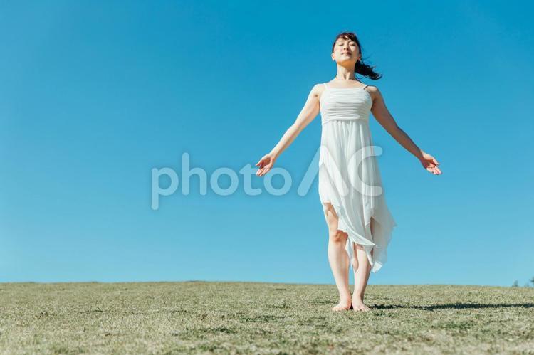 空と白いワンピースの踊る女性（深呼吸） 深呼吸,リフレッシュ,デトックスの写真素材