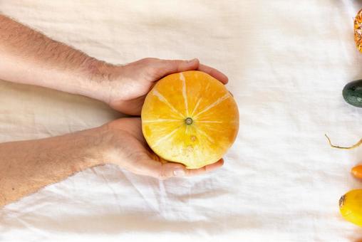 両手で持っているカボチャ カボチャ,黄色,オレンジ色の写真素材