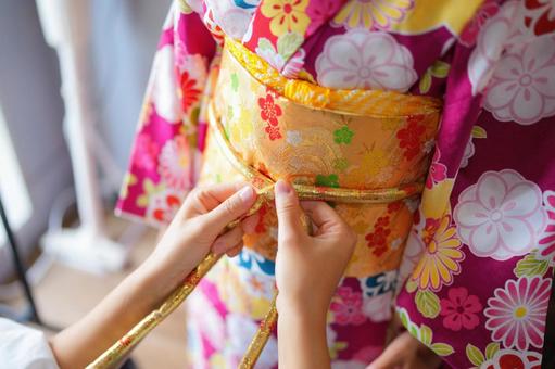 着付けの仕上げに帯を結ぶ手の動き 着付けの仕上げに帯を結ぶ手の動き 七五三,お参り,七五三参りの写真素材