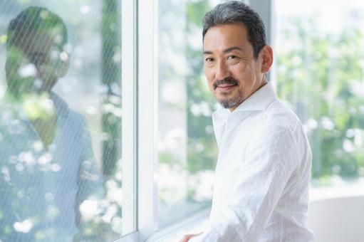 リビングでスキンケアをするミドルの男性 ビューティー,スキンケア,男性の写真素材