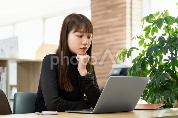 パソコンの画面を見ながら考える女性 女性,パソコン,考えるの写真素材