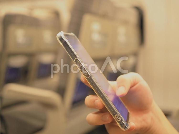 新幹線車内でスマホを見る男性の手元 スマホ,携帯電話,見るの写真素材