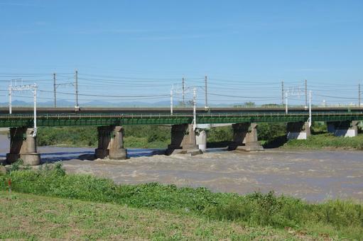 増水した多摩川と、鉄道の鉄橋 増水した多摩川と、鉄道の鉄橋の写真