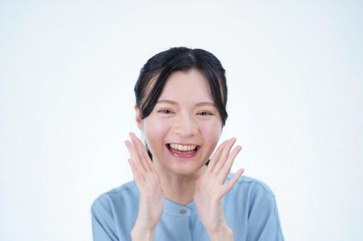 女性が頬に手を当てて笑う 女性,笑顔,叫ぶの写真素材