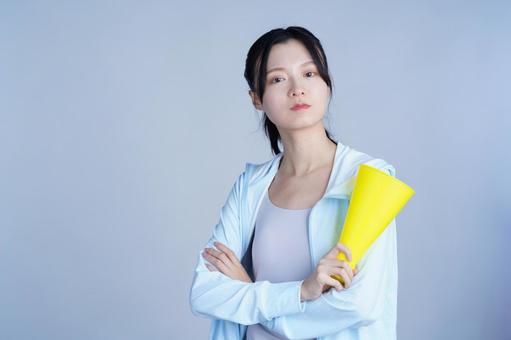水色の服の女性が黄色いメガホンを持ち考えるの写真