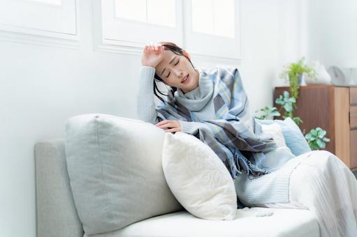 ソファに座る女性 疲労,咳,体調管理の写真素材