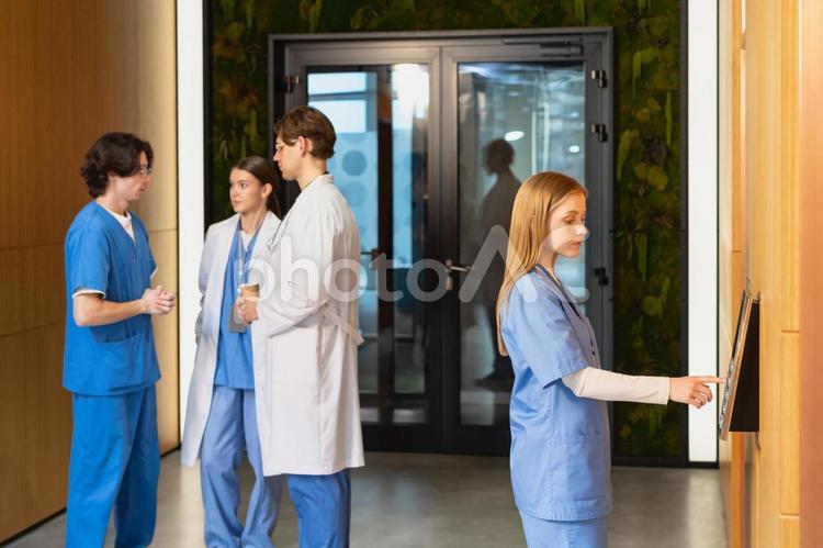 エレベーターにエレベーターにこれから乗る女性と話す医療従事者 男性,女性,白衣の写真素材