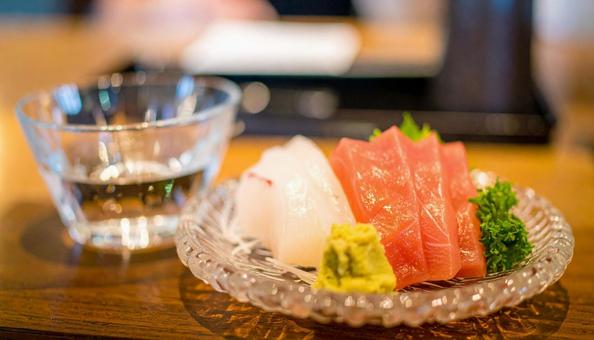 ガラスの皿に盛られた刺し身と日本酒 ガラスの皿に盛られた刺し身と日本酒の写真