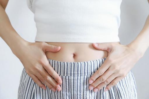 お腹を押さえる女性の手元 お腹を押さえる女性の手元 お腹,腹部,下腹部の写真素材
