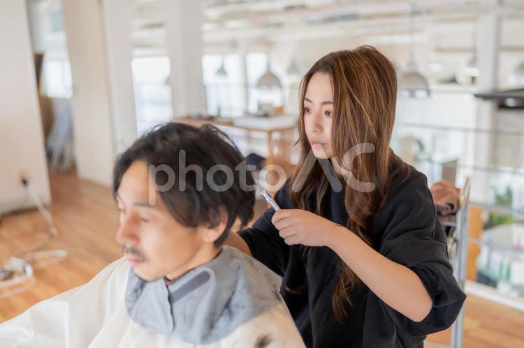 男性客のスタイルの確認をする女性美容師 ビジネス,ビジネスウーマン,キャリアウーマンの写真素材
