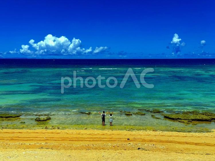 沖縄　真夏のビーチでバンザイする子供たち 海,沖縄,砂浜の写真素材