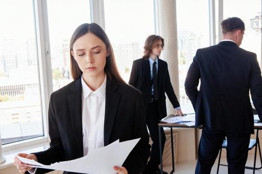 真剣な顔で書類を見る女性 男女,女性,資料の写真素材