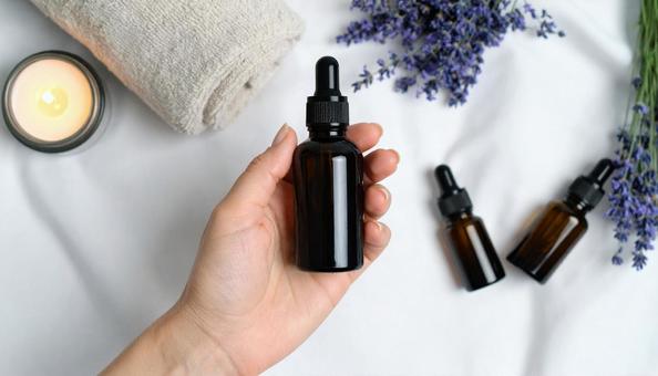 アロマオイルを手に取る女性の手 アロマオイルを手に取る女性の手の写真