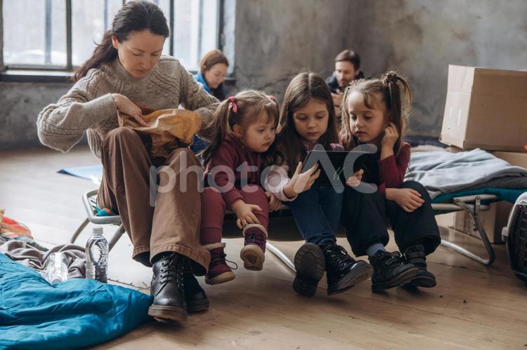 座って紙袋を見る女の子とタブレットを見る女の子たち 女性,女の子,人物の写真素材