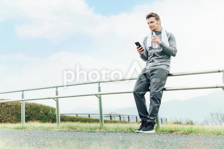 運動・トレーニング中にスマホを使う男性 運動,スマホ,音楽の写真素材