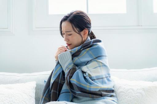 ソファに座る女性 疲労,咳,体調管理の写真素材