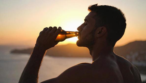 ビール瓶のビールを飲む男性のシルエット ビール瓶のビールを飲む男性のシルエットの写真