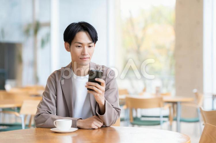 カフェでくつろぐ若い男性 カフェ,男性,カフェテリアの写真素材