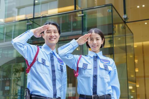 敬礼をする日本人男性警備員と女性警備員 警備員,敬礼,挨拶の写真素材